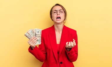pretty woman looking desperate, frustrated and stressed. business and dollar banknotes concept