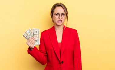 pretty woman feeling puzzled and confused. business and dollar banknotes concept