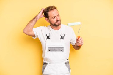 middle age man smiling happily and daydreaming or doubting. painting home concept