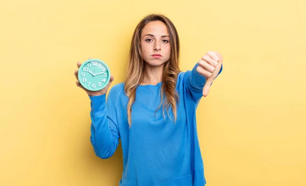 Pretty Woman Feeling Cross Showing Thumbs Holding Alarm Clock — Stockfoto