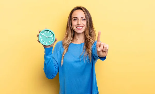 Pretty Woman Smiling Proudly Confidently Making Number One Holding Alarm — Stockfoto
