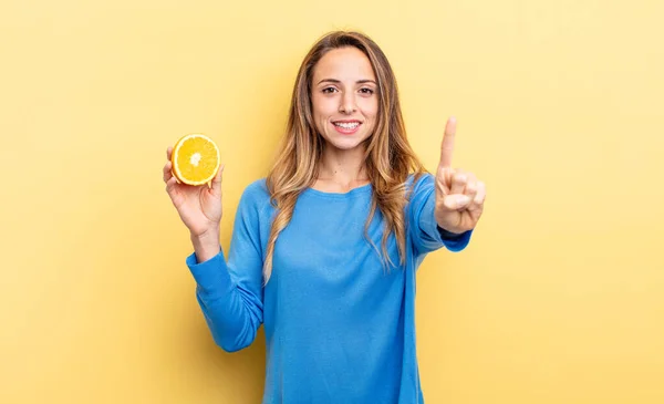 Pretty Woman Smiling Looking Friendly Showing Number One Holding Half — Stok fotoğraf