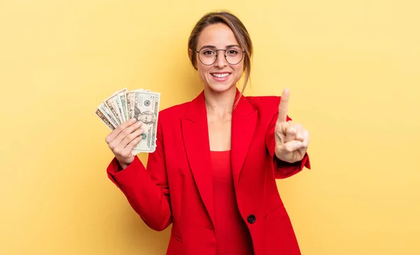 Pretty Woman Smiling Looking Friendly Showing Number One Business Dollar — Zdjęcie stockowe