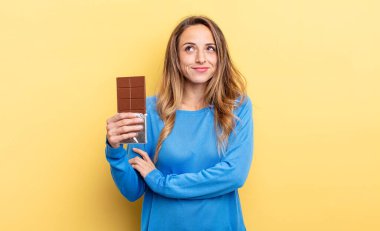 pretty woman shrugging, feeling confused and uncertain. chocolate concept