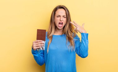 pretty woman looking unhappy and stressed, suicide gesture making gun sign. chocolate concept