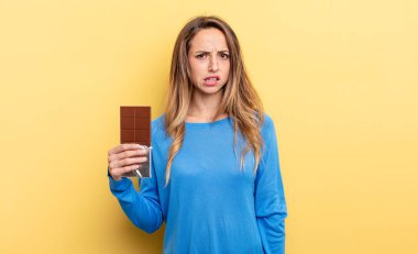 pretty woman feeling puzzled and confused. chocolate concept