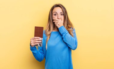 pretty woman covering mouth with hands with a shocked. chocolate concept