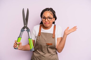 Siyah afro kadın şaşkın, şaşkın ve şüpheci hissediyor. Bahçıvan ya da çiftçi konsepti