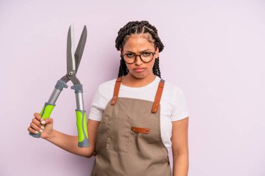 Siyah afro kadın üzgün, üzgün ya da kızgın ve yana bakıyor. Bahçıvan ya da çiftçi konsepti