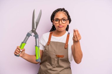 Siyah afro kadın kapiş ya da para hareketi yapıyor, sana ödemeni söylüyor. Bahçıvan ya da çiftçi konsepti