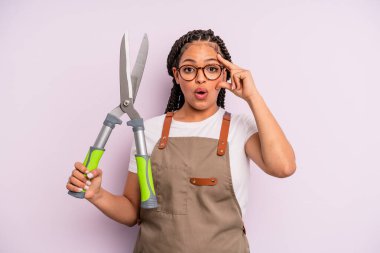 Siyah afro kadın şaşırmış görünüyor, yeni bir düşünce, fikir ya da konsept fark ediyor. Bahçıvan ya da çiftçi konsepti