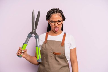 Siyah afro kadın iğreniyor, sinirleniyor ve dili dışarı çıkıyor. Bahçıvan ya da çiftçi konsepti