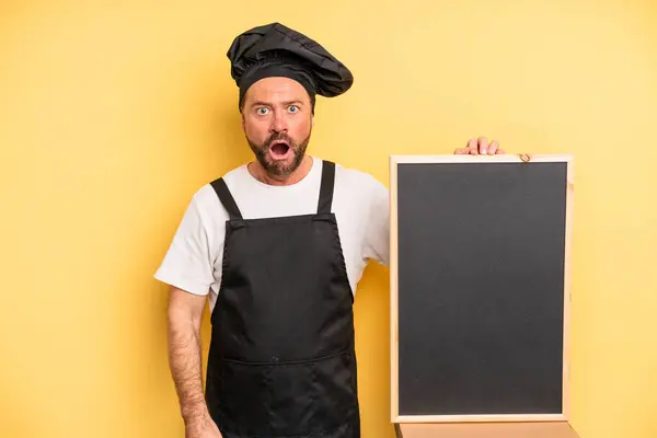 Middle Age Man Looking Very Shocked Surprised Chef Blackboard Concept — Foto de Stock