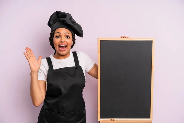 Black Afro Woman Feeling Happy Astonished Something Unbelievable Chef Blackboard — Stock Photo, Image