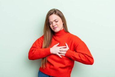 Kafkasyalı kızıl saçlı kadın üzgün, yaralı ve kalbi kırık görünüyor, iki elini de kalbe yakın tutuyor, ağlıyor ve bunalımda.