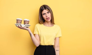 Güzel kadın şaşkın ve şaşkın hissediyor. kahve konseptini kaldır.