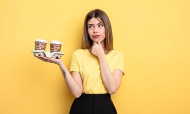 Düşünen, kuşkucu ve kafası karışık güzel bir kadın. kahve konseptini kaldır.