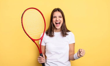 pretty woman shouting aggressively with an angry expression. tennis player concept