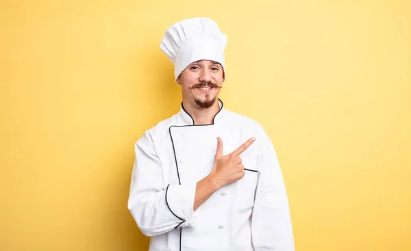 Chef Homem Sorrindo Alegremente Sentindo Feliz Apontando Para Lado — Fotografia de Stock