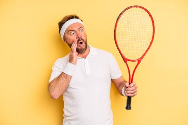 middle age man feeling happy, excited and surprised. tennis concept