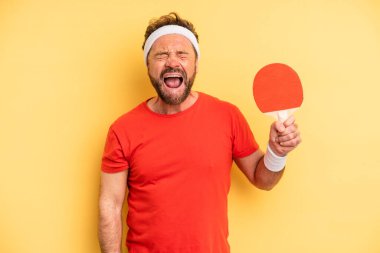 middle age man shouting aggressively, looking very angry. ping pong concept