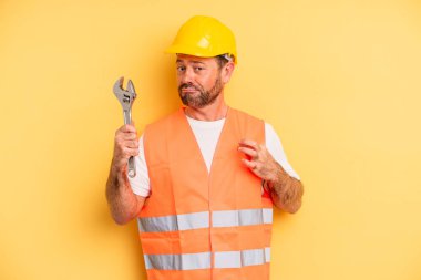 middle age man looking arrogant, successful, positive and proud.  breakdown car repair wrench concept