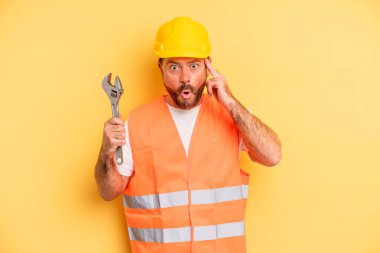 middle age man looking surprised, realizing a new thought, idea or concept.  breakdown car repair wrench concept