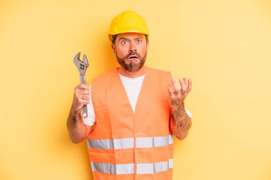 middle age man looking desperate, frustrated and stressed.  breakdown car repair wrench concept