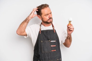 Orta yaşlı bir adam mutlu bir şekilde gülümsüyor ve hayal kuruyor ya da şüphe ediyor. berber konsepti