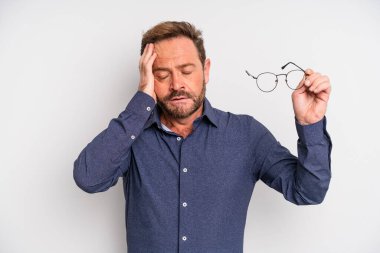 Orta yaşlı bir adam, bıkkın, yorgun ve uykulu hisseder. görünüm sorunları ve gözlük konsepti