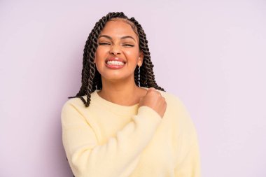 Siyah afro kadın kendini mutlu hissediyor ve meydan okumayla yüzleşiyor ya da kutluyor