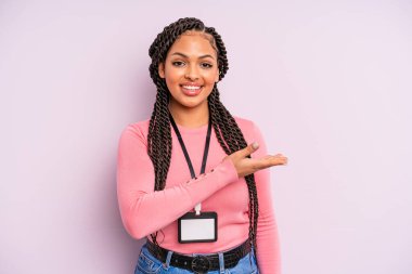 Siyah afro kadın neşeyle gülümsüyor, mutlu hissediyor ve bir konsept gösteriyor. akreditasyon VIP kartı