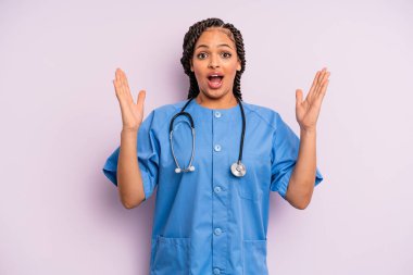 Siyah afro kadın kendini mutlu hissediyor ve inanılmaz bir şeye hayret ediyor. hemşire konsepti