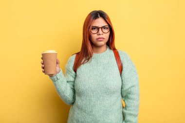 Hispanik kadın üzgün, üzgün ya da kızgın ve yana bakıyor. Kahve konsepti olan bir öğrenci