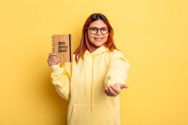 İspanyol kadın mutlu bir şekilde gülümsüyor ve bir konsept sunuyor. Geri dönüşüm kavramı