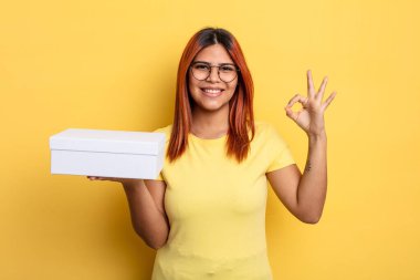 İspanyol kadın kendini mutlu hissediyor, iyi bir jestle onaylıyor. boş ambalaj kavramı