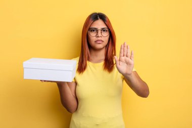 İspanyol kadın ciddi görünüyor. Avuç içini gösteriyor. Durdurma hareketi yapıyor. boş ambalaj kavramı