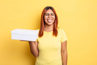 Neşeli ve asi tavırlı İspanyol kadın, şaka yapıyor ve dil çıkarıyor. boş ambalaj kavramı