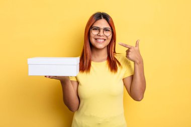 İspanyol kadın kendine güvenerek gülümseyerek kendi gülüşünü gösterdi. boş ambalaj kavramı