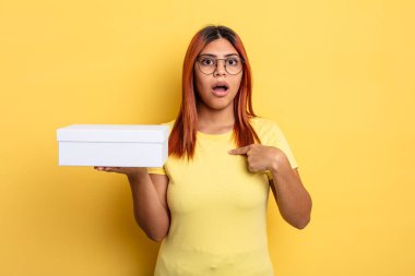 İspanyol kadın şok olmuş ve ağzı açık, kendini işaret ederek şaşırmış görünüyor. boş ambalaj kavramı