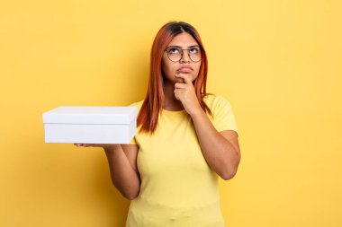 Hispanik kadın düşünüyor, kuşkulu ve şaşkın hissediyor. boş ambalaj kavramı