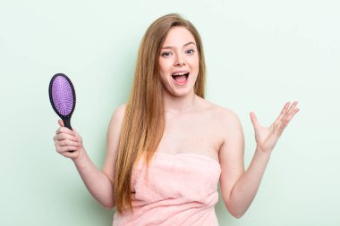 Kızıl saçlı kadın kendini mutlu hissediyor, bir çözüm ya da fikir bulduğuna şaşırıyor. saç tarağı konsepti