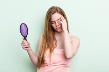 Kızıl saçlı kadın bıkkın, yorgun ve uykulu hissediyor. saç tarağı konsepti