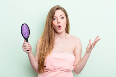 Kızıl saçlı kadın şok olmuş ve şaşırmış hissediyor. saç tarağı konsepti