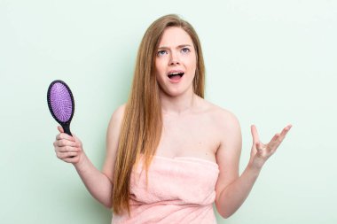 Kızıl saçlı kadın umutsuz, hayal kırıklığına uğramış ve stresli görünüyor. saç tarağı konsepti