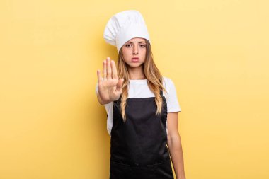 pretty woman feeling stressed, anxious or scared, with hands on head. chef concept