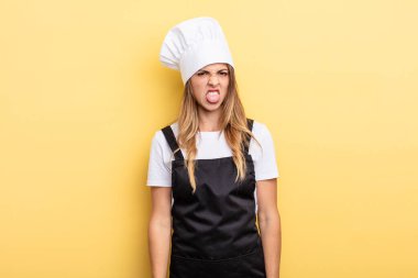 pretty woman feeling disgusted and irritated and tongue out. chef concept