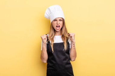 pretty woman shouting aggressively with an angry expression. chef concept