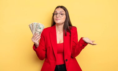 pretty woman feeling puzzled and confused and doubting. dollar banknotes concept
