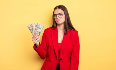 pretty woman feeling sad, upset or angry and looking to the side. dollar banknotes concept